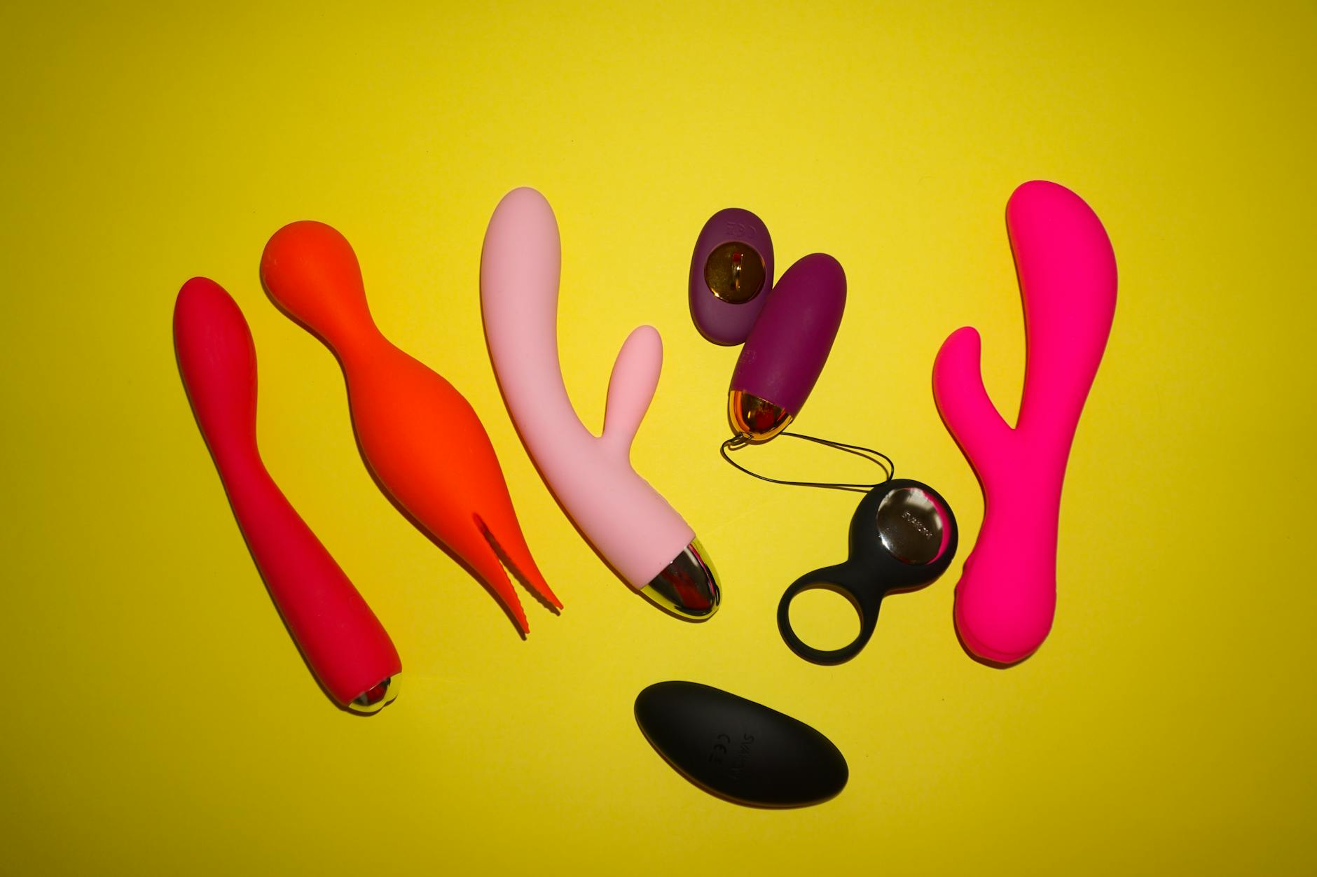 Colorful lemon vibrators and sex toys displayed on a bright yellow background