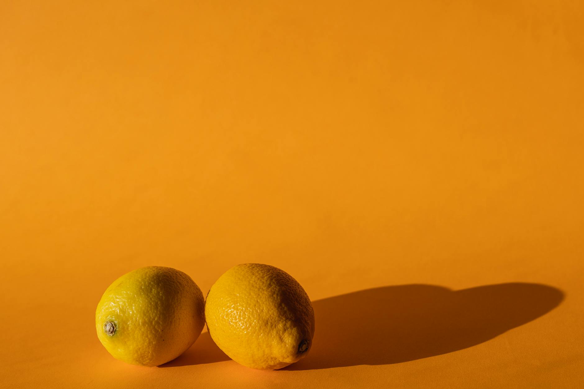 Colorful sex toys including lemon vibrators arranged on bright yellow background